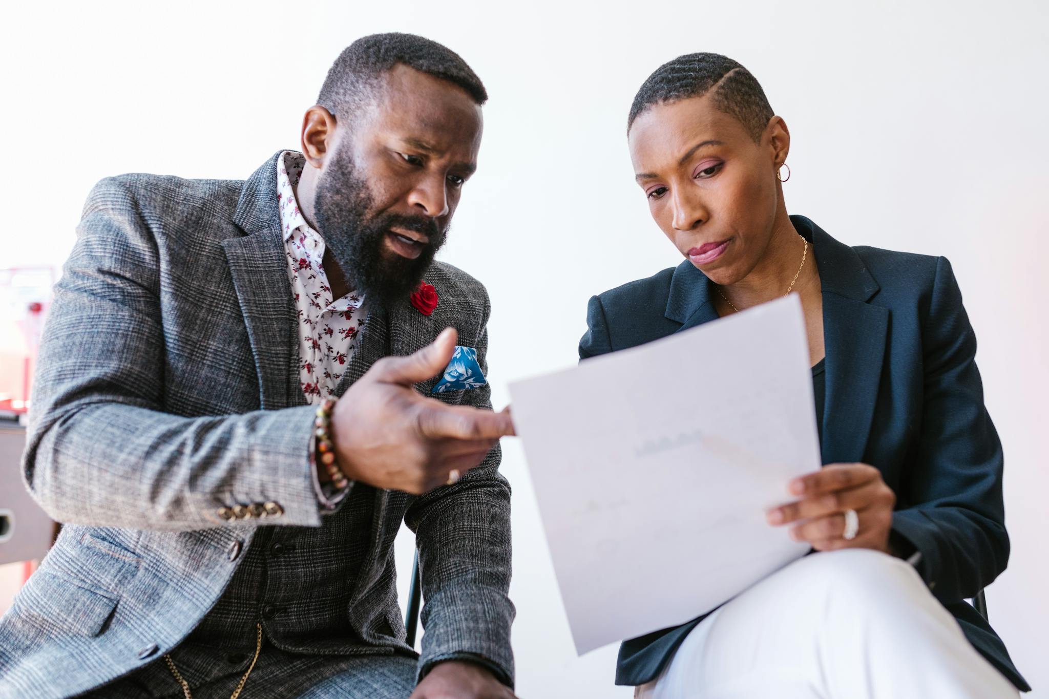 Two business professionals reviewing a document together in an office setting.
